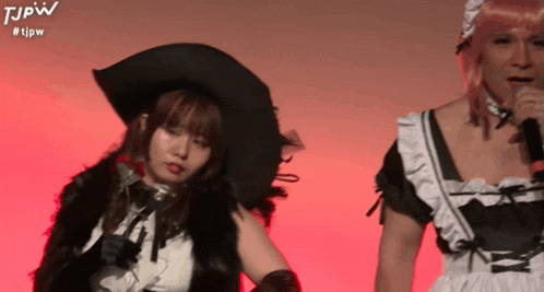 a man in a maid costume is standing next to a woman in a witch costume
