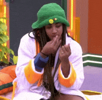 a woman with dreadlocks wearing a green hat