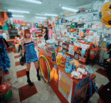 a woman in a blue dress stands in a store surrounded by toys