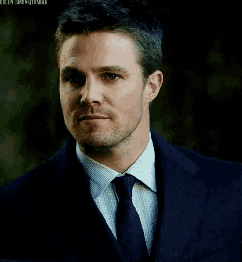 a man in a suit and tie is looking at something
