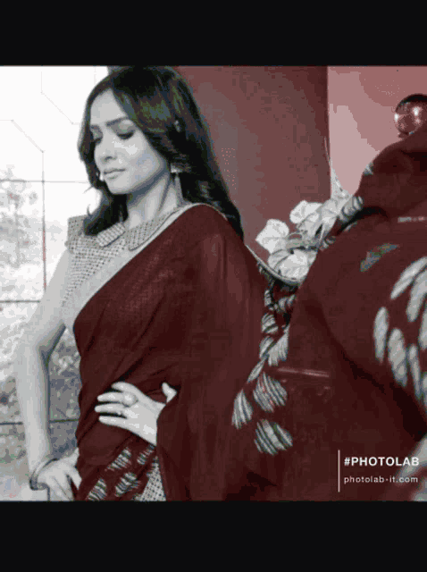 a black and white photo of a woman wearing a maroon colored saree