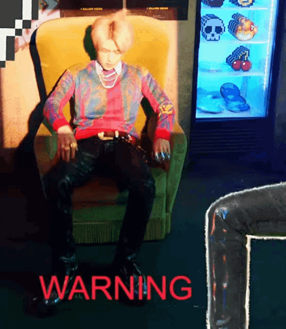 a man is sitting in a chair with the word warning in red letters