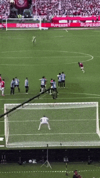 a soccer game is being played on a field with a superbet banner in the background