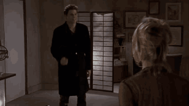 a man and a woman are standing in front of a screen
