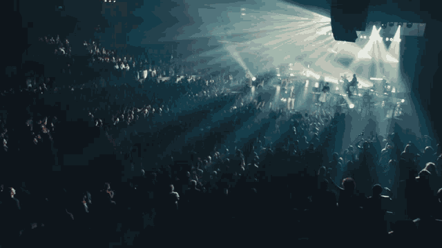 a crowd of people at a concert watching a band