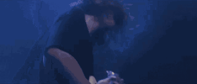 a man is playing a white electric guitar on a stage .