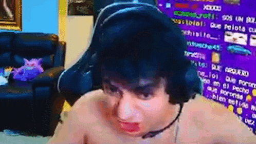 a shirtless man wearing a headset is making a funny face .