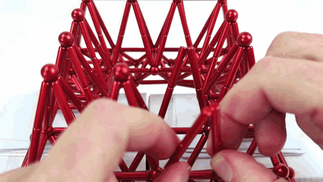 a person is playing with a red toy that looks like a pyramid