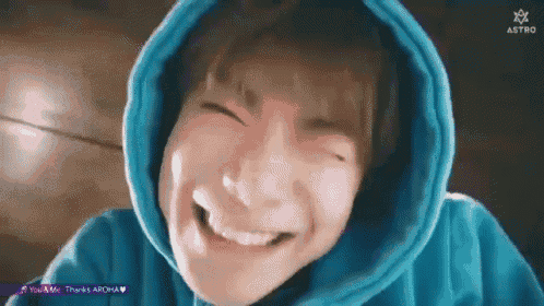 a close up of a person wearing a blue hoodie making a face .