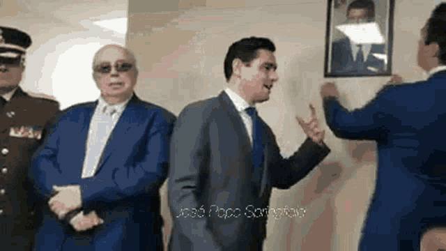 a man in a suit is talking to another man in a blue suit
