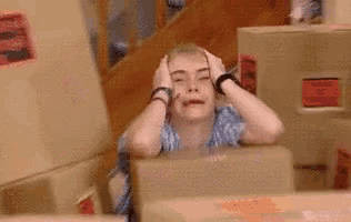 a woman is sitting in a chair with her hands on her head .