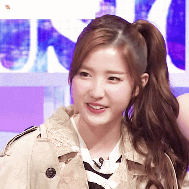 a woman with a ponytail wearing a trench coat and a striped shirt