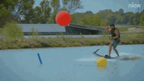 a man riding a wakeboard in a lake with a nick logo on the bottom