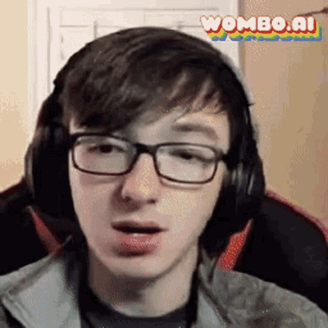 a young man wearing glasses and headphones is sitting in a chair and looking at the camera .