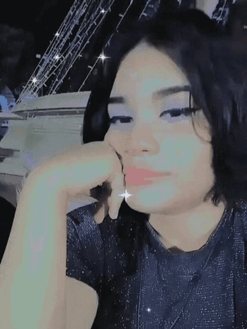 a girl with a hand on her face looks at the camera