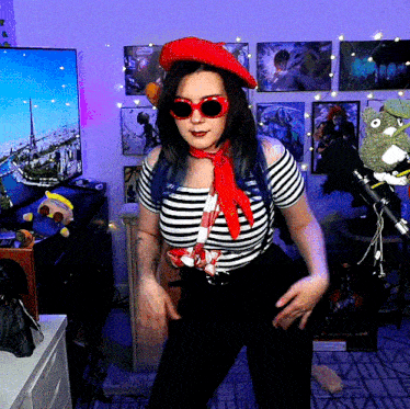 a woman wearing a red hat and sunglasses is dancing in front of a tv