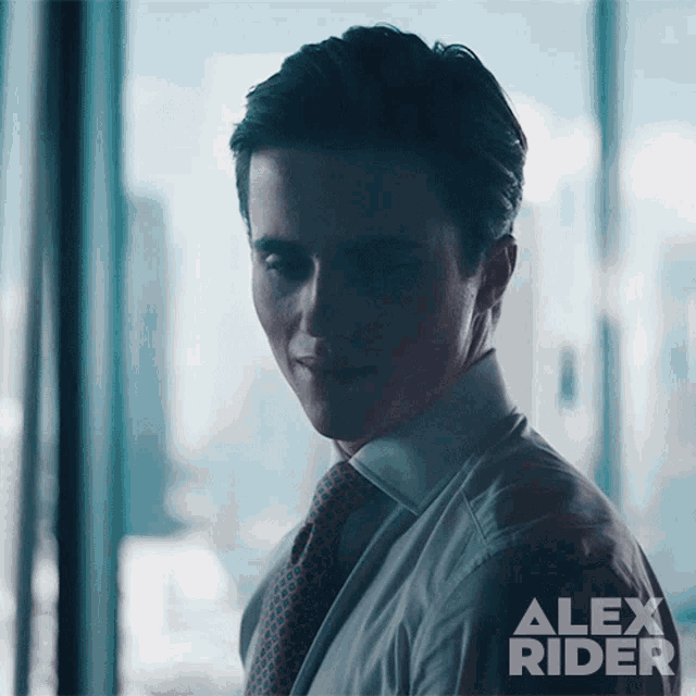 a man in a suit and tie with alex rider written on the back of his shirt