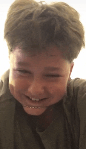 a young boy with braces on his teeth is smiling for the camera