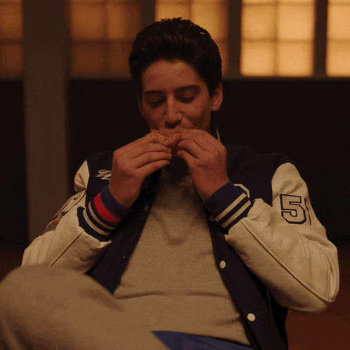 a man in a varsity jacket with the number 5 on it