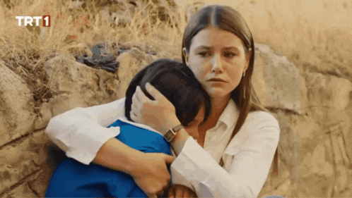 a woman hugging a child with trt1 written on the bottom right