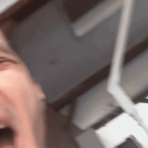 a close up of a person 's face with a white object in the background