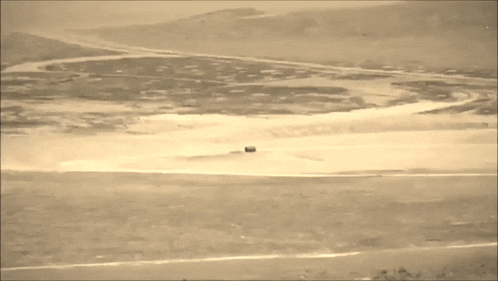 a large explosion in the middle of a field with smoke coming out of it