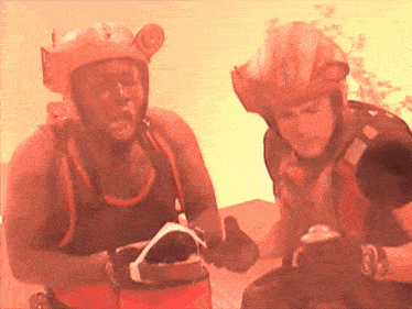 a man wearing a helmet with the letter n on it is talking to another man