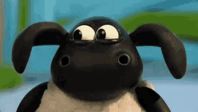 timmy the sheep from the cartoon shaun the sheep is looking at the camera with big eyes .