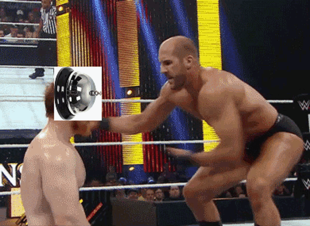 a man in a wrestling ring with a tire on his head