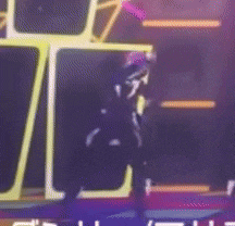 a person is standing on a stage in front of a sign that says ' s ' on it .