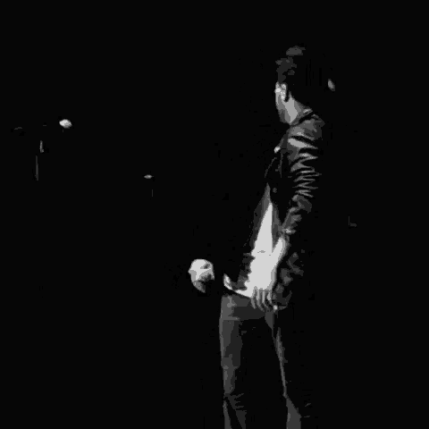 a couple of men are standing next to each other in a dark room .
