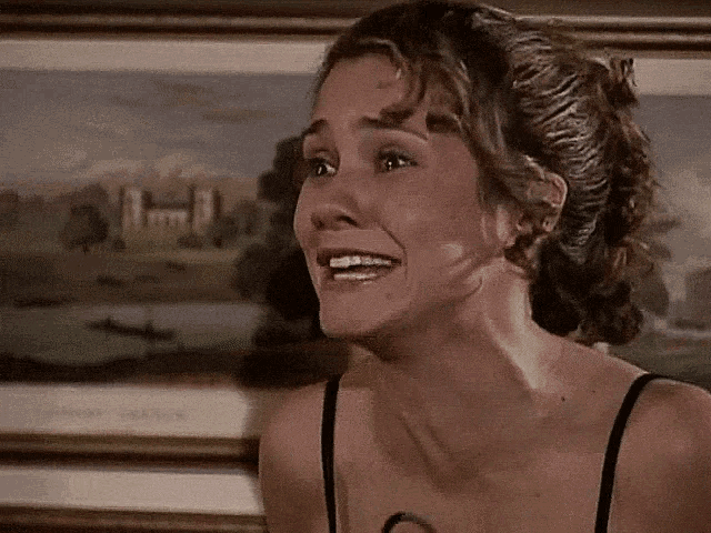 a woman is smiling in front of a framed painting of a lake