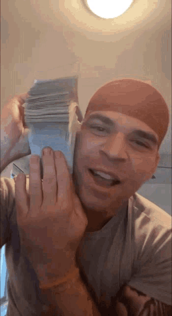 a man in a red headband is holding a stack of money in his hands