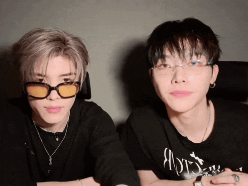 two young men wearing sunglasses and a shirt that says ' a ' on it are sitting next to each other