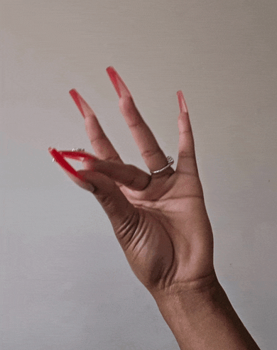 a woman 's hand with long red nails and a silver ring on her finger