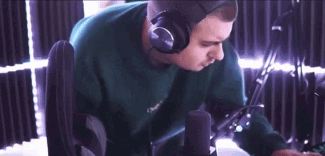 a man wearing headphones is sitting in front of a microphone