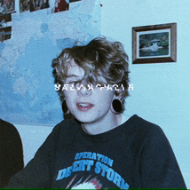 a young man wearing a black operation desert storm shirt