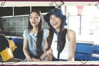 two young women are standing next to each other in a kitchen wearing hats and smiling .