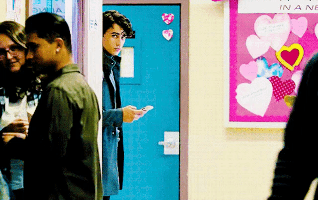 a group of people standing in front of a bulletin board that says in a new