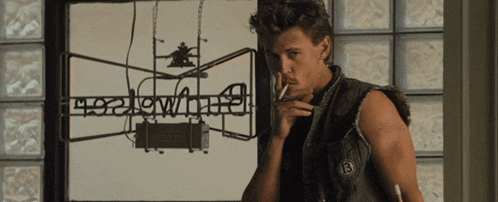 a man smoking a cigarette in front of a sign that says " heavyweight "