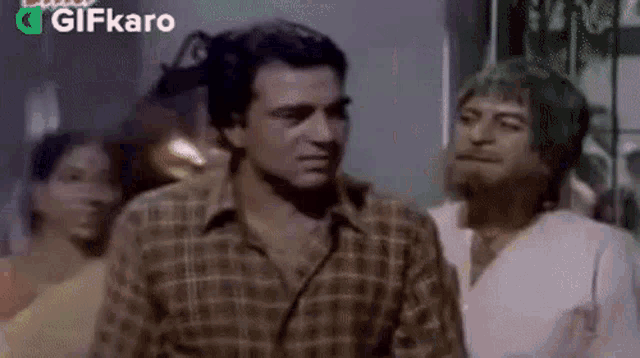 a group of men are standing next to each other in a room in a movie .