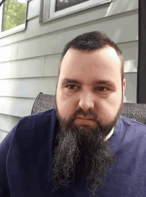 a man with a long beard and a blue shirt