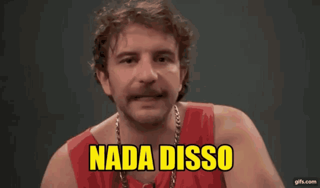 a man wearing a red tank top and a chain around his neck is making a funny face and saying nada disso .