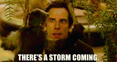 a man is standing next to a monkey with the words `` there 's a storm coming '' written on it .