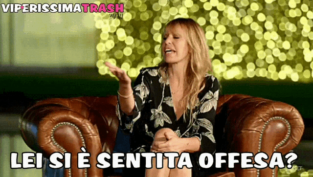 a woman is sitting in a chair with the words lei si e sentita offesa written below her