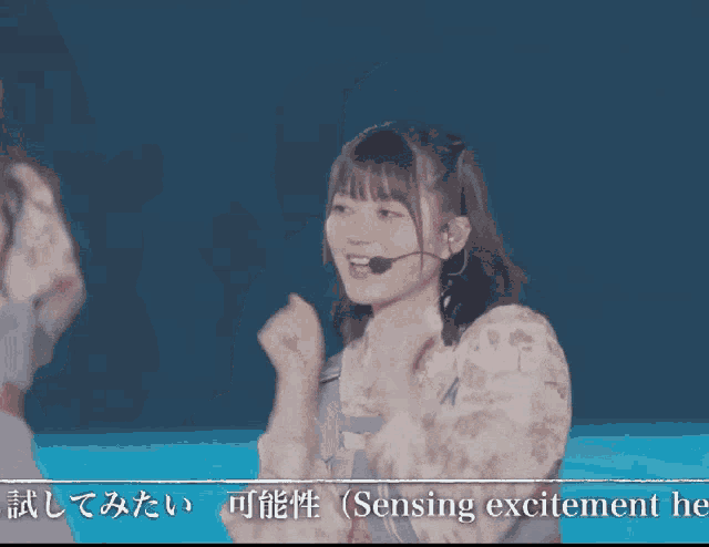 a girl with a microphone in her ear says sensing excitement here