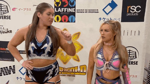 two female wrestlers are standing in front of a wall that says lafine