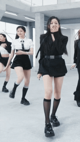 a group of women are dancing in a room and one of them is wearing black shorts