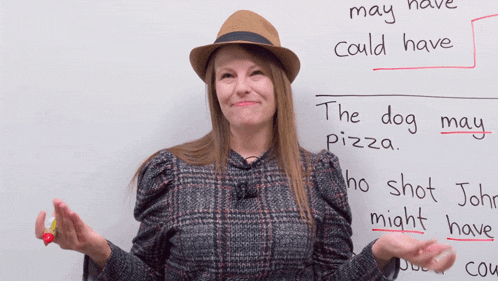 a woman wearing a hat stands in front of a white board that says " the dog may pizza "