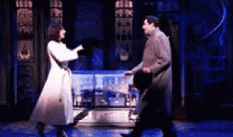 a man and a woman are dancing together on a stage .